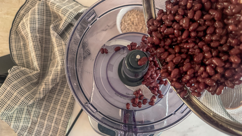 adding beans to food processor