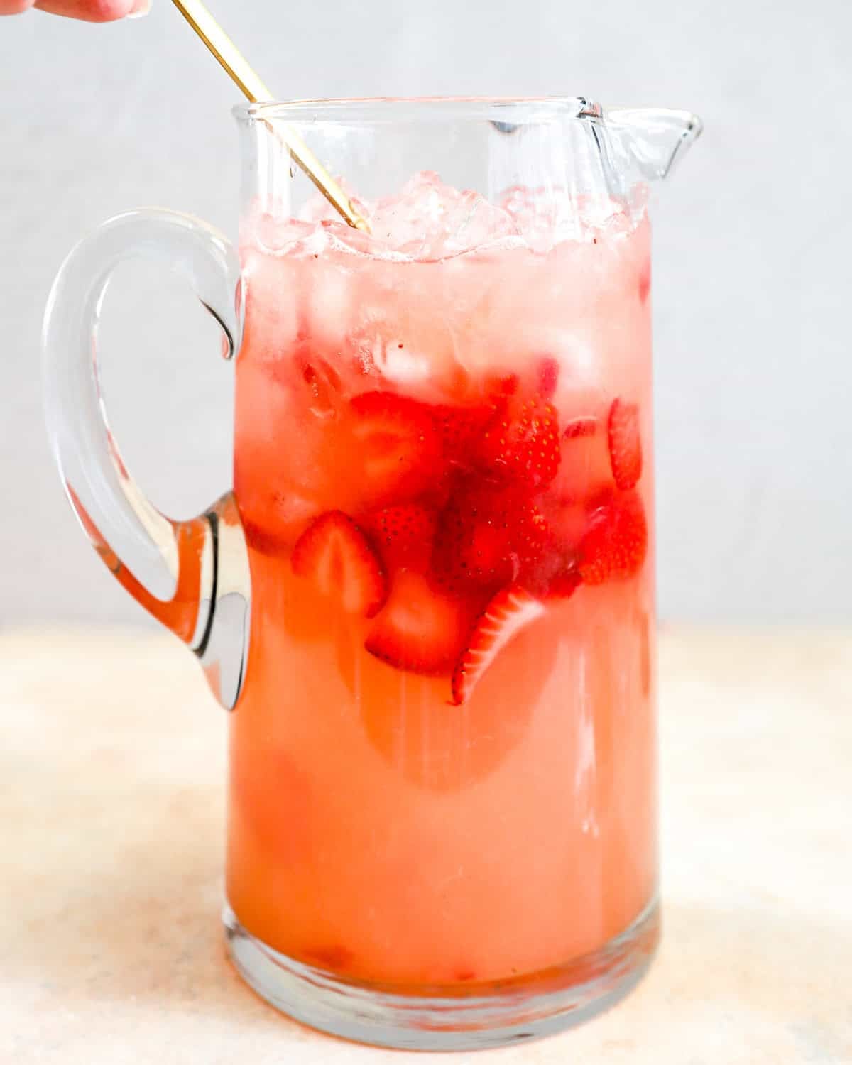 adding strawberries to strawberry lemonade