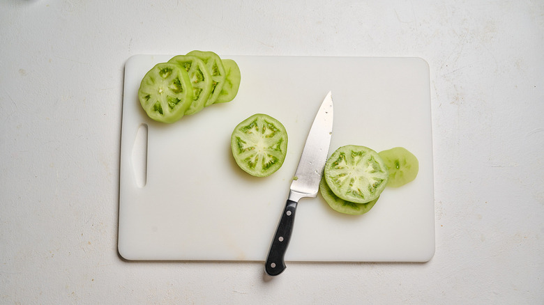 tomatoes sliced into thick slices on a cutting board