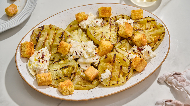 platter of green tomatoes, burrata, and croutons
