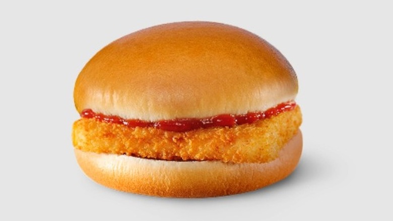 A McDonald's McFish sandwich featuring a fried fish patty topped with ketchup on a steamed bun