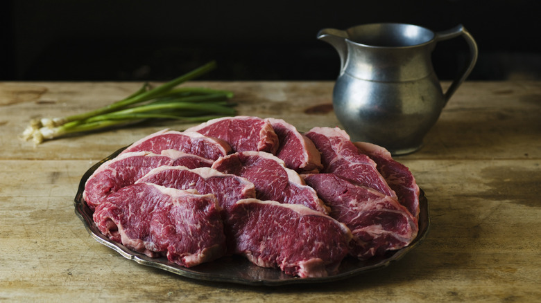 Raw cuts of beef on silver platter