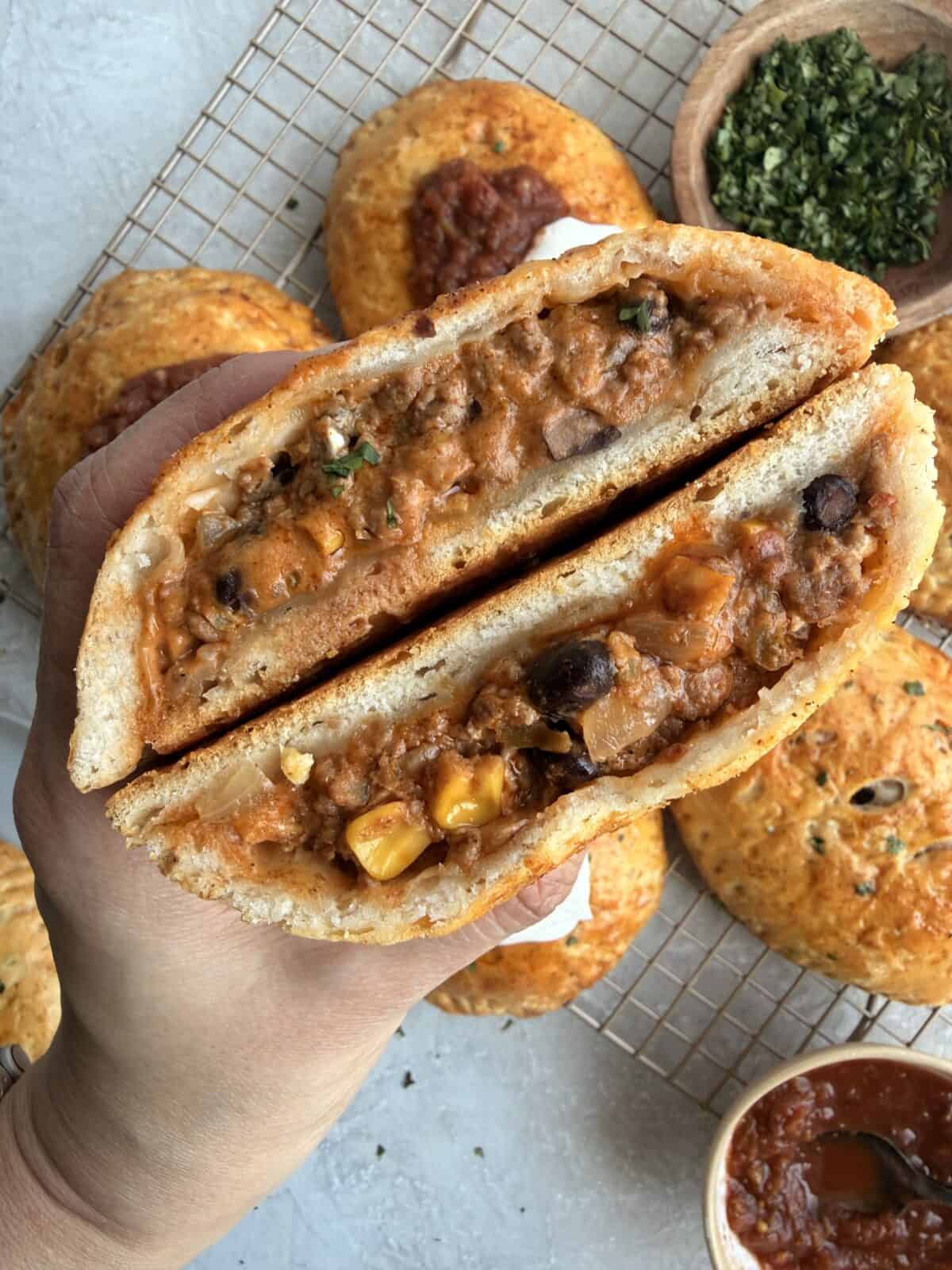 Close-up of a Loaded Taco Hot Pocket sliced in half, showing the beef, corn, and black bean filling.