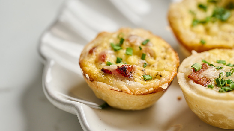 Close up of mini bacon And Gruyère quiche cups on plate