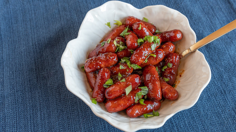 Bowl of spicy little smokies, garnished with fresh parsley