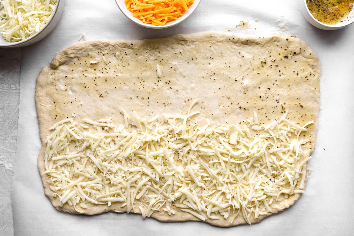 first layer of cheese added to cheesy bread