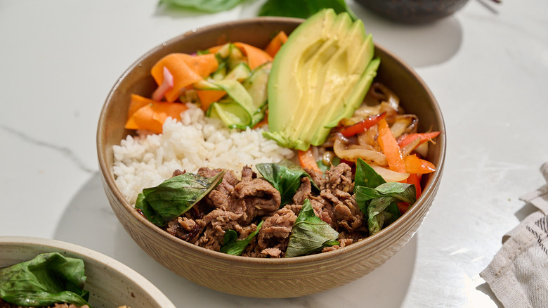 bowl of thai basil beef and rice on a table