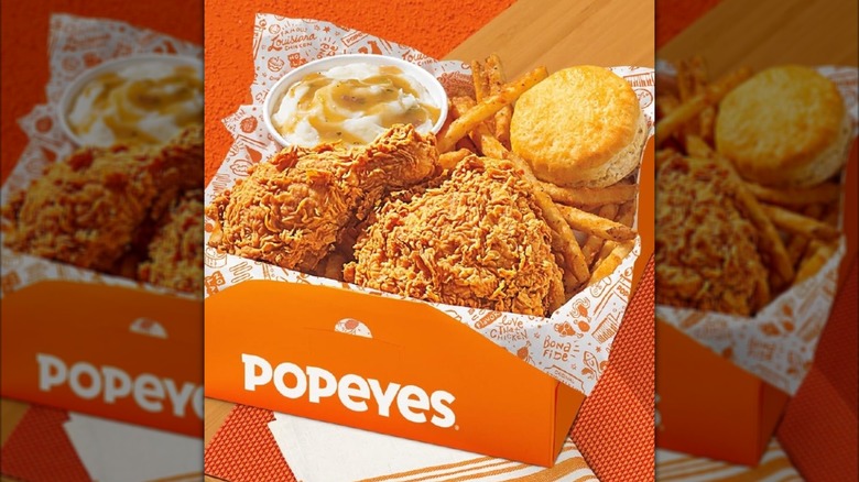 Popeyes Big Box meal combo with fried chicken, fries, biscuit, and mashed potatoes in orange box