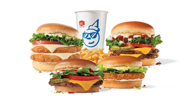Cheeseburgers, chicken sandwiches, fries, and drink cup from Jack in the Box﻿ on white background