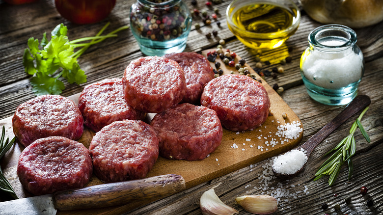 fresh raw hamburger patties arranged on a cutting board