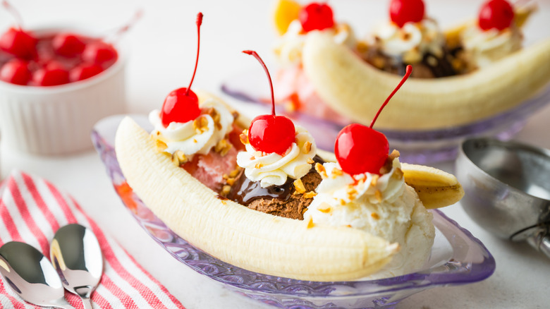 banana split with cherries and nuts in purple bowl