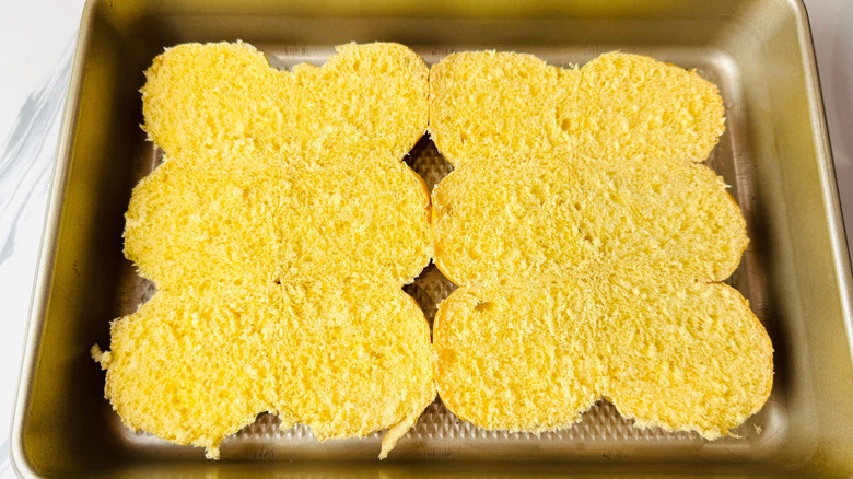 Bottom halves of brioche buns in baking pan