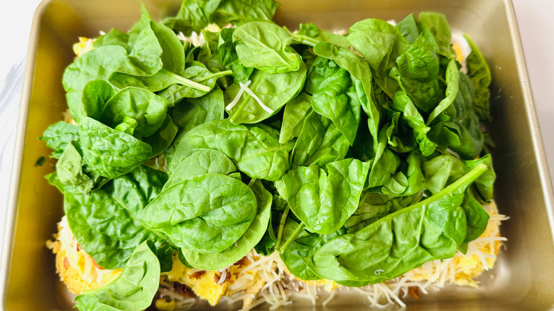Scrambled eggs, cheese, and spinach layered in baking pan