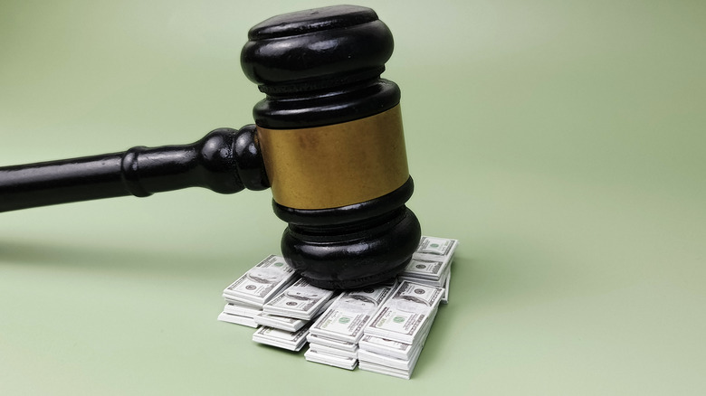 A gavel balanced on a stack of American money