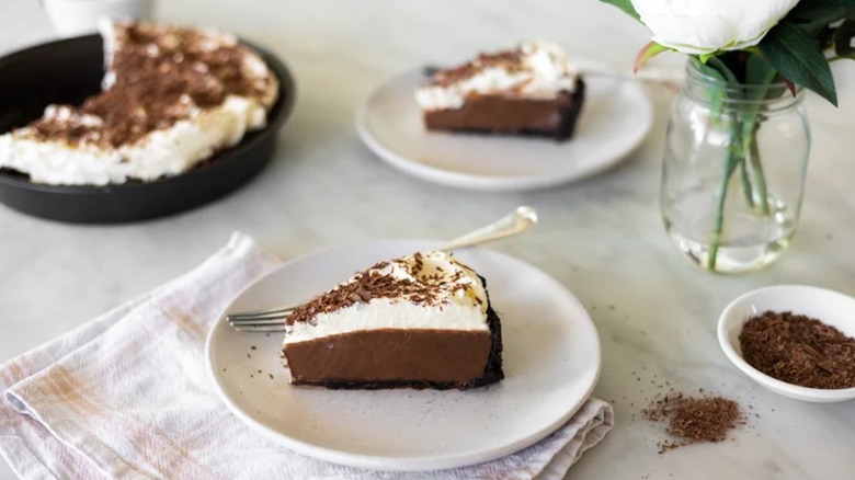 Slice of chocolate cream pie on white plate