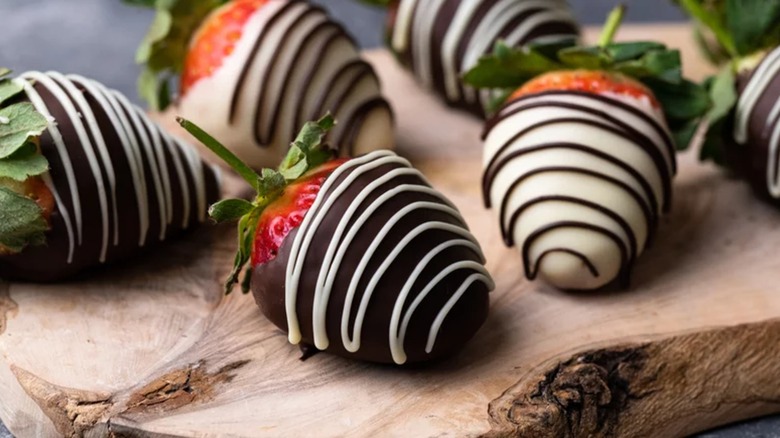 Chocolate-covered strawberries on wooden board