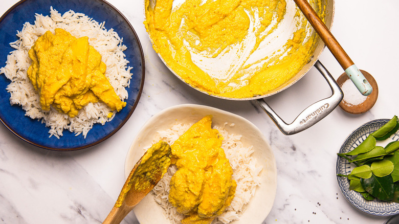 Ladling mango curry over rice.