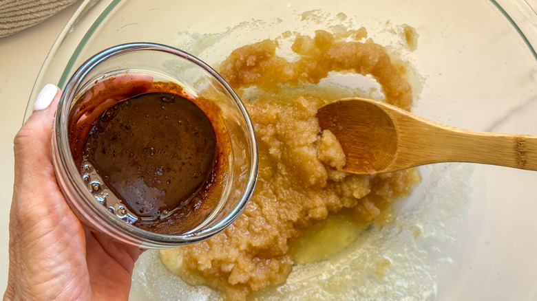 hand adding espresso paste to bowl