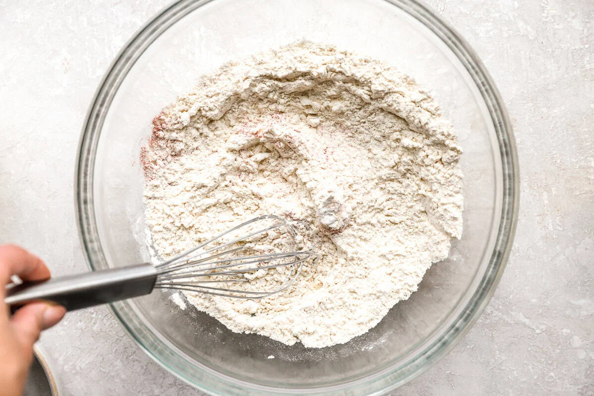 woman's hand whisking together dry ingredients for onion rings