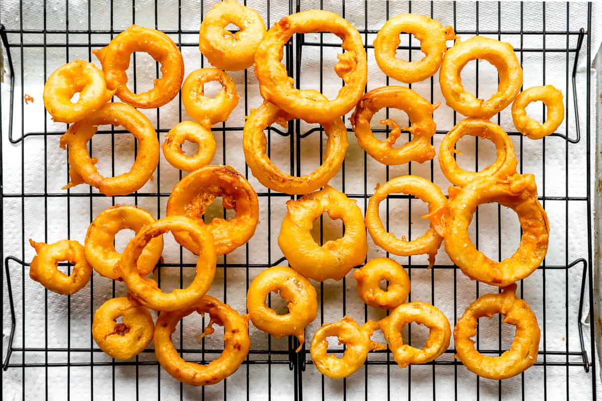 homemade onion rings on a baking sheet cooling