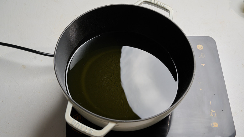 heating oil in a pot on a stove