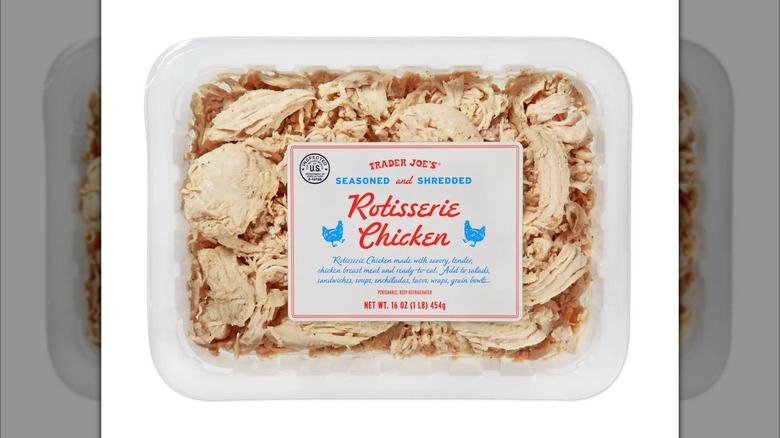 Plastic tub of Trader Joe's Seasoned and Shredded Rotisserie Chicken on white background
