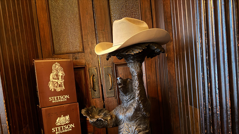 Bear statue holding Stetson hat, Stetson Bourbon boxes stacked up
