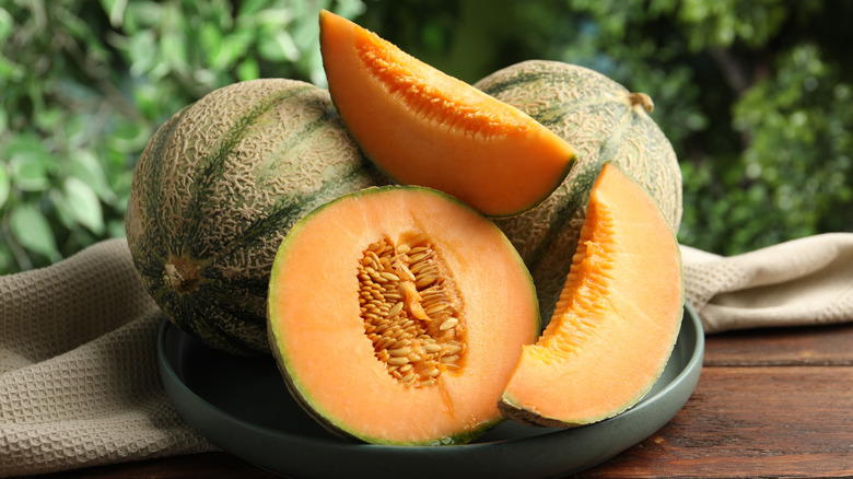 A stack of ripe, sliced cantaloupes with seeds