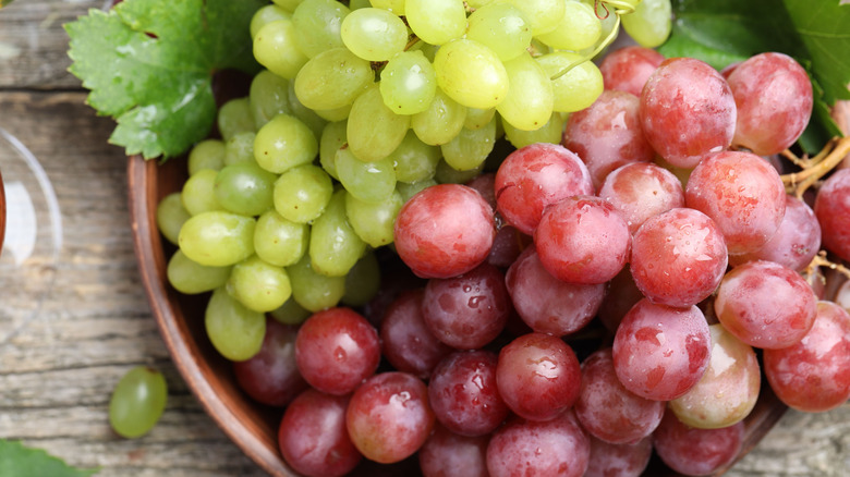 A bowl of green and red grapes