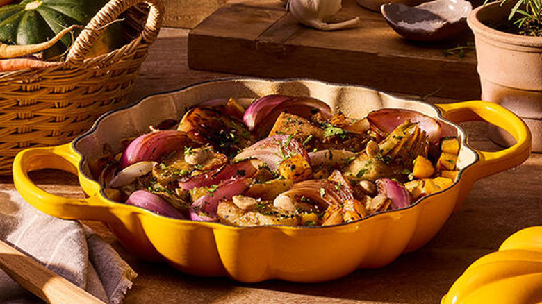 The Signature Pumpkin Braiser with the lid off filled with colorful roasted vegetables.