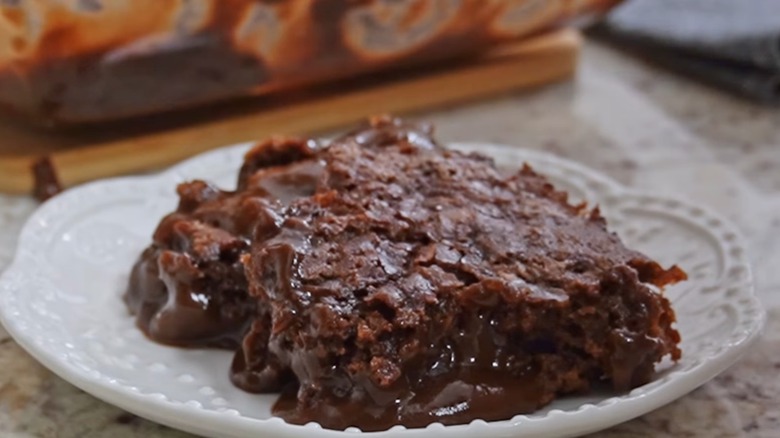Two slices of chocolate pudding cake on a white plate