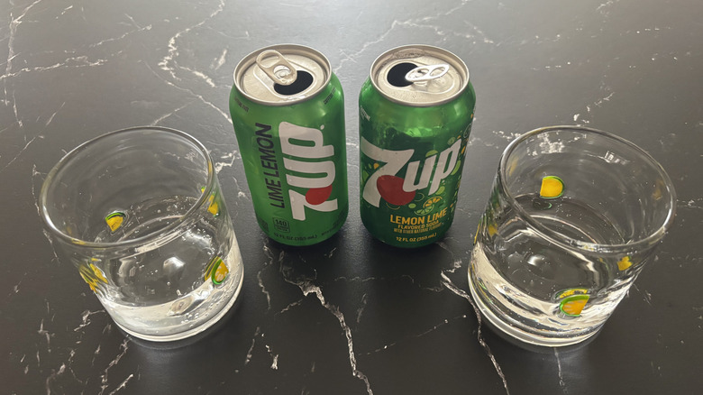 7Up cans with glasses half full with clear soda