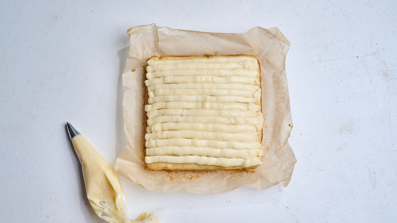 frosting the cake with a piping bag
