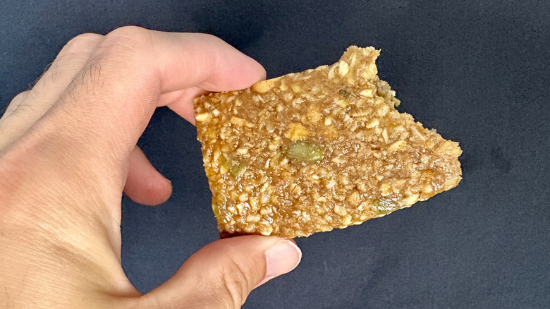 hand holding partially eaten granola bar