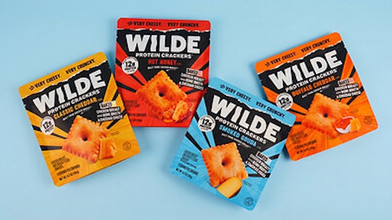 Wilde Protein Crackers in different flavors against a light blue background.