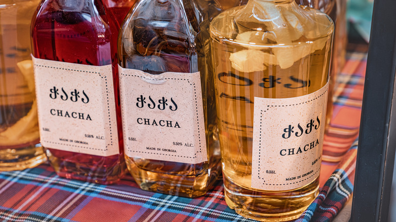 Chacha, a strong Georgian spirit, presented in various flavored bottles on display.
