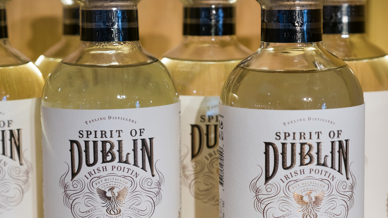 Close-up label shot of Irish poitin bottles stacked close to each other.