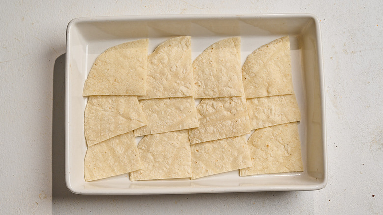 tortillas spread into a casserole dish