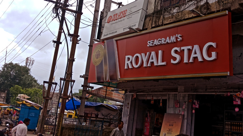 A sign proudly advertizes royal stag whisky on the street
