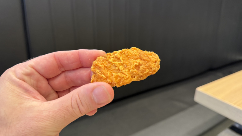 a single Spicy Chicken McNugget in hand