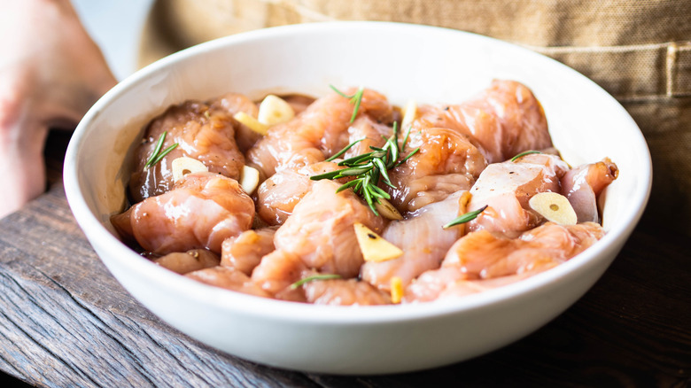 Chicken marinating in bowl.