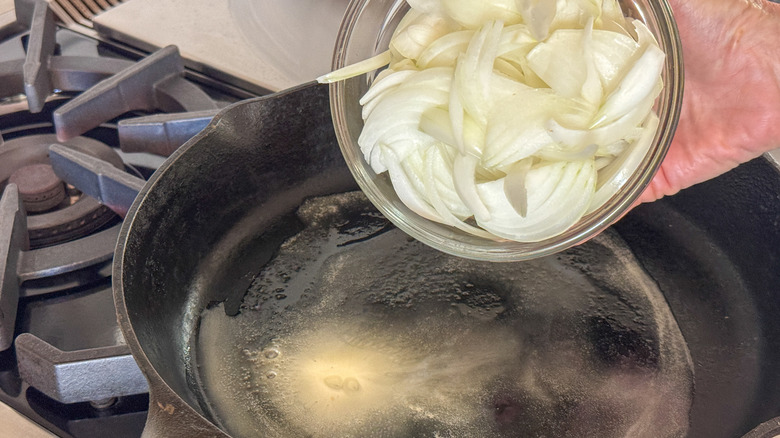 adding onions to skillet with melted butter