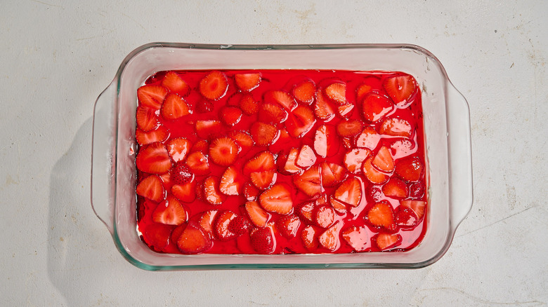 pouring jell-o over cool whip in casserole dish