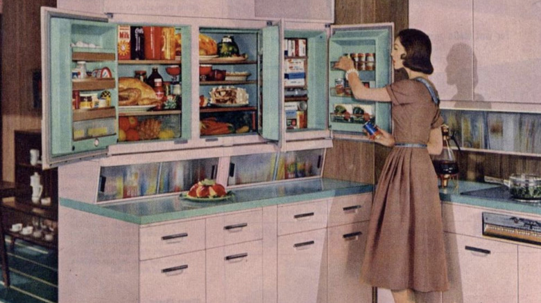 Illustrated advertisement of woman getting food out of a pink 1950s GE Wall Refrigerator-Freezer