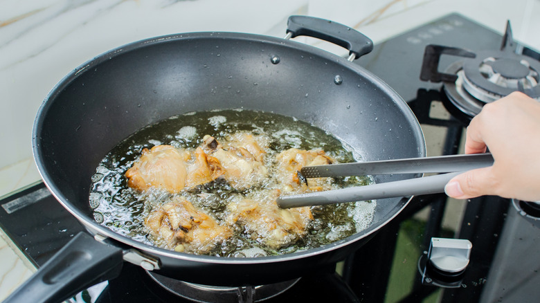 Deep frying chicken in a wok