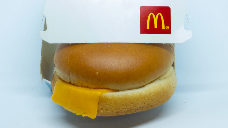 American cheese hanging out the side of a Filet-O-Fish sandwich in a cardboard box