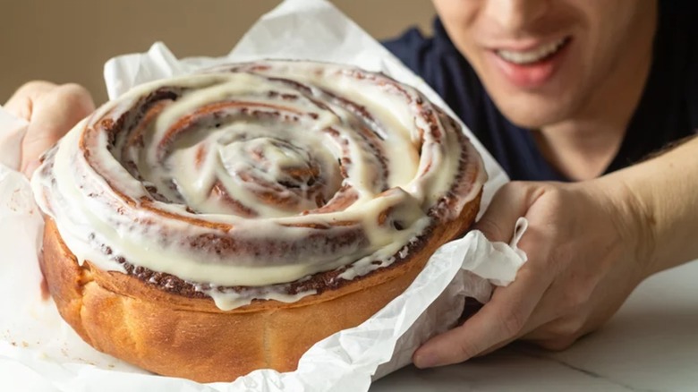 Man holding giant cinnamon roll