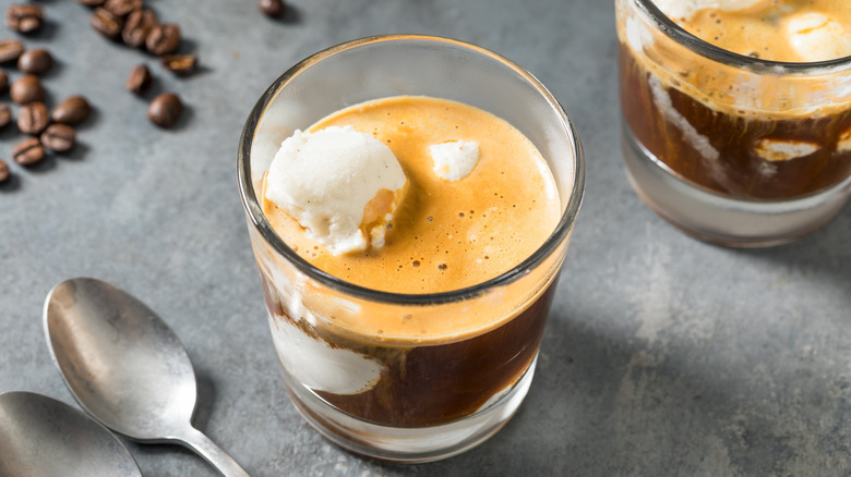 top view of affogato in a glass next to spoons and coffee beans