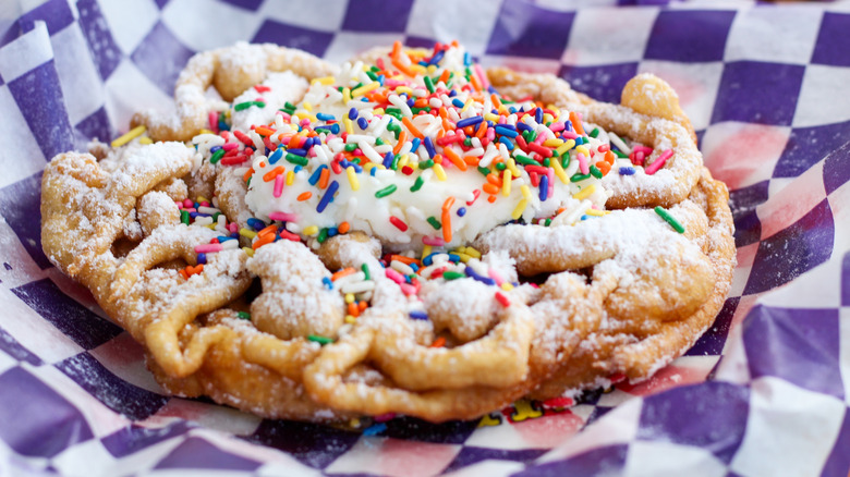 A funnel cake with colorful sprinkles on top