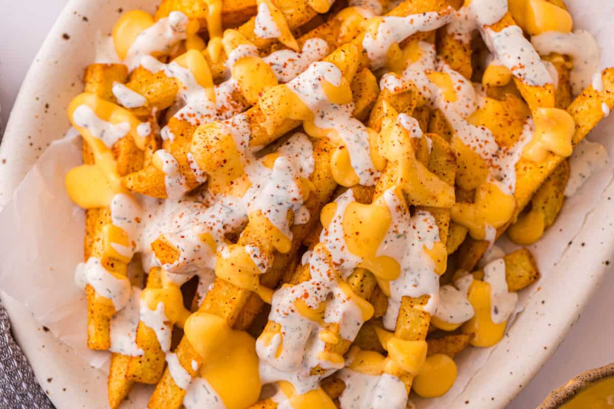 Close-up of Louisiana Voodoo Fries topped with warm cheese sauce and cool ranch.